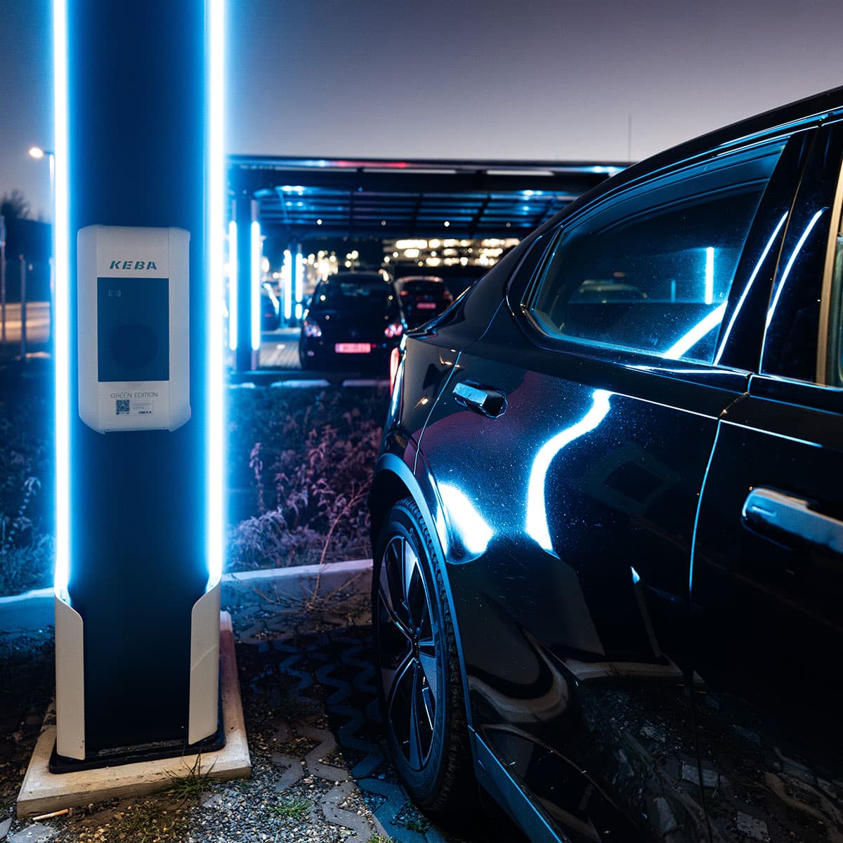 Ladeinfrastruktur für die Mobilität von morgen Elektrofahrzeug beim Laden an einer modernen Ladesäule mit Solardach