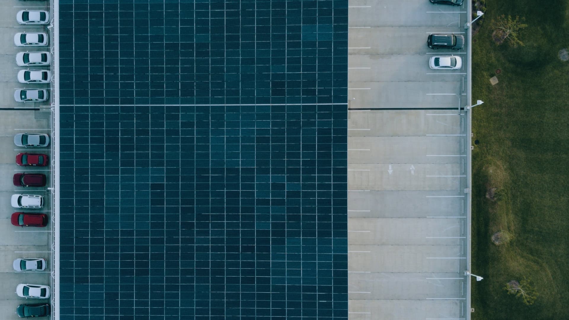 Photovoltaikanlage auf Parkplatz – Luftaufnahme Luftbild einer großflächigen Parkplatzanlage mit Solardach über den Stellplätzen