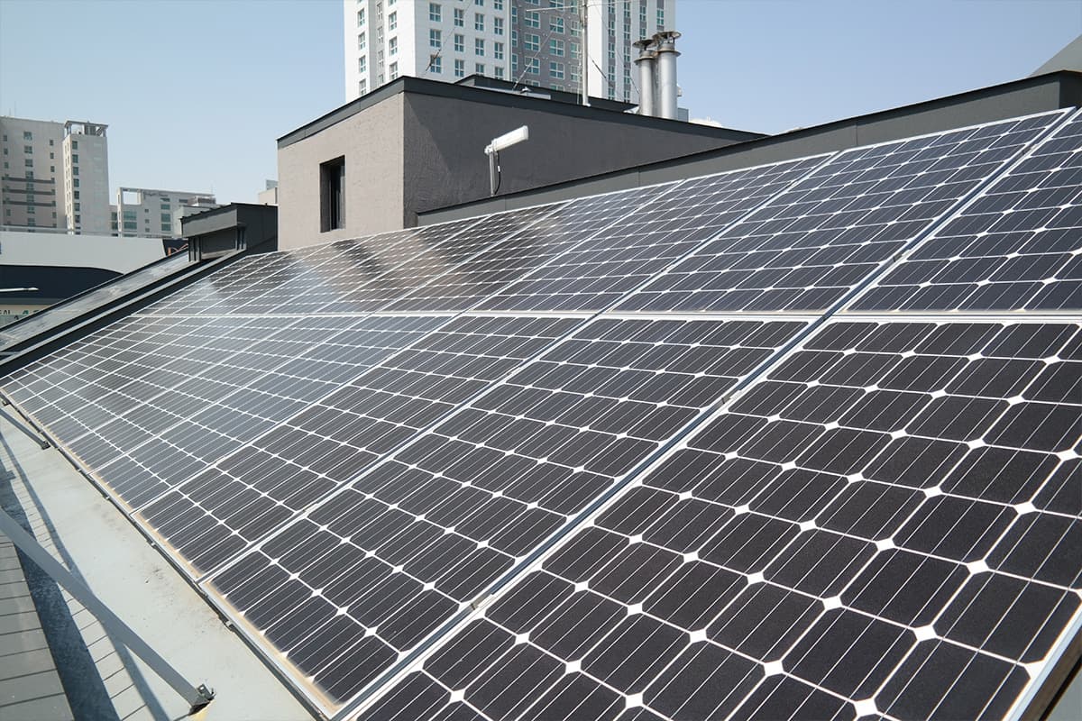 Solaranlage auf Flachdach im urbanen Umfeld PV-Anlage auf einem modernen Flachdach in einer Stadt mit Hochhäusern im Hintergrund